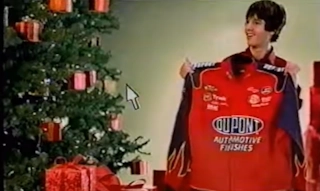 Screenshot from JCPenney's Unwrap the Magic commercial with a kid holding up a Jeff Gordon NASCAR jacket.